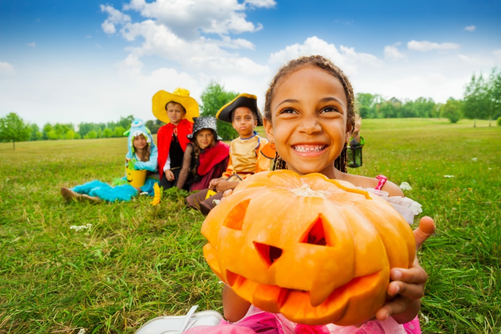 Little girl holding a halloween pumpkin