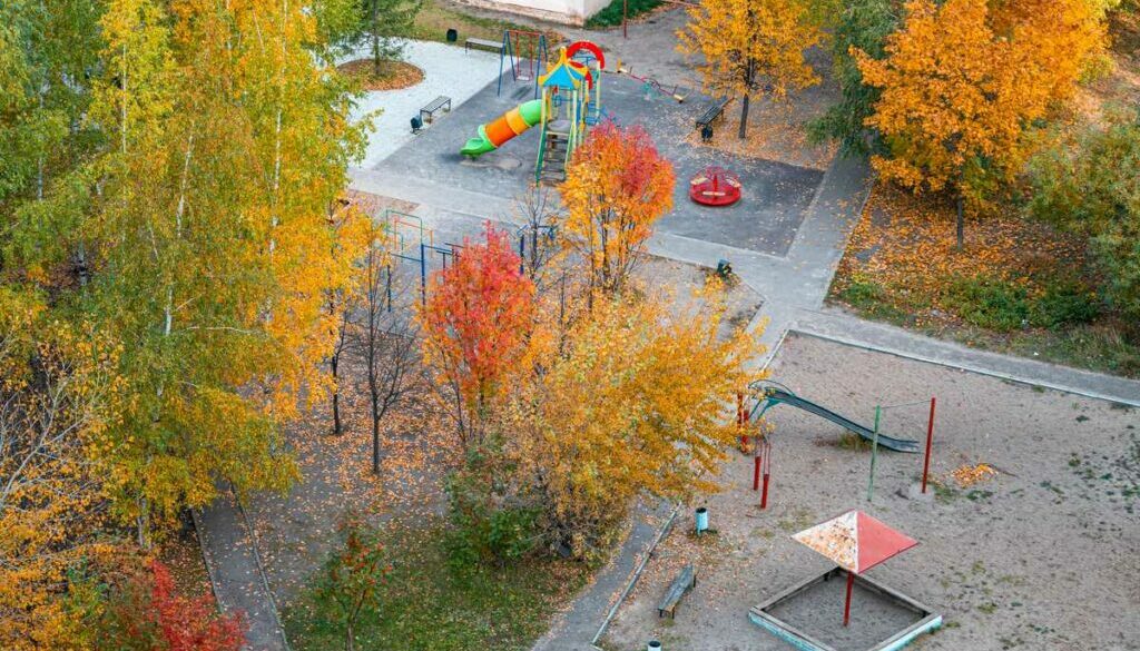 Children's playground covered with autumn leaves