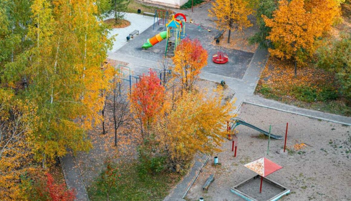 Children's playground covered with autumn leaves