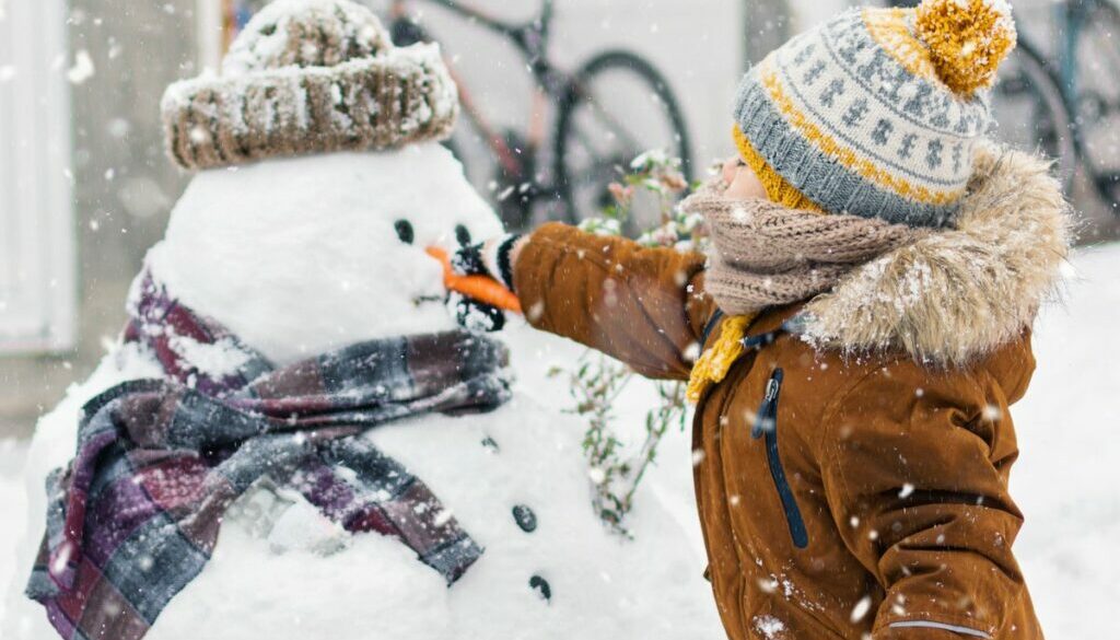 Daycare toddler playing with snowman