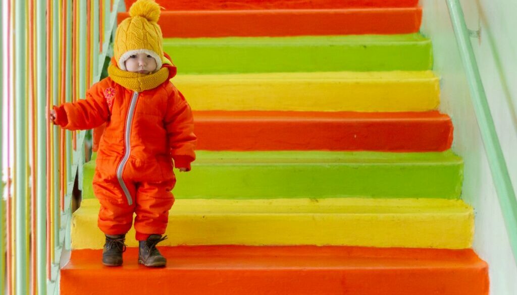 Toddler goes down the stairs in kindergarten