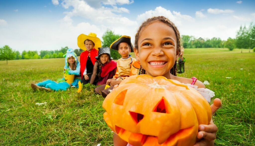 Little girl holding a halloween pumpkin