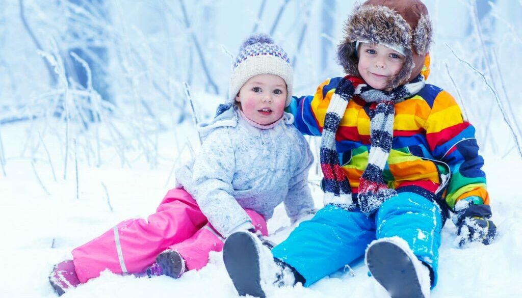 Children playing in winter hat in snow forest